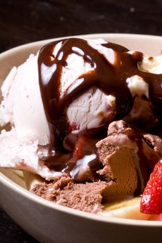 ice cream covered in chocolate shot close up dark background