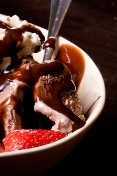 ice cream covered in chocolate shot close up dark background