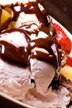 ice cream covered in chocolate shot close up dark background