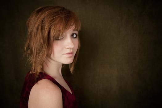 Pretty young girl with red hair on a green background