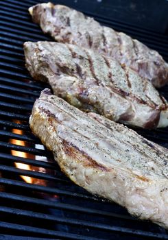 Grilling steaks on the grill nice cuts of meat close up shot shallow DOF