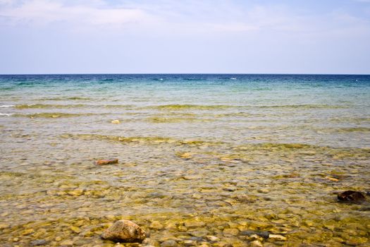 landscape shot of lake huron on the beach bright blue colors rocks in the foreground