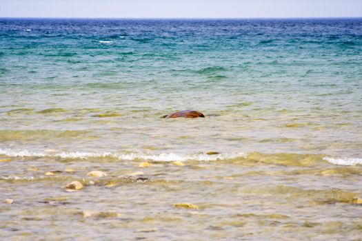 landscape shot of lake huron on the beach bright blue colors rocks in the foreground