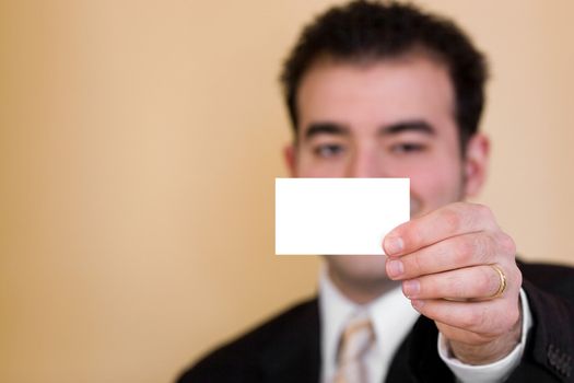 Close up of a man holding a business card up.  Plenty of copyspace for your logo or design.  Shallow depth of field.