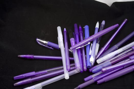 Pile of purple pens just waiting for someone to pick one up and start writing