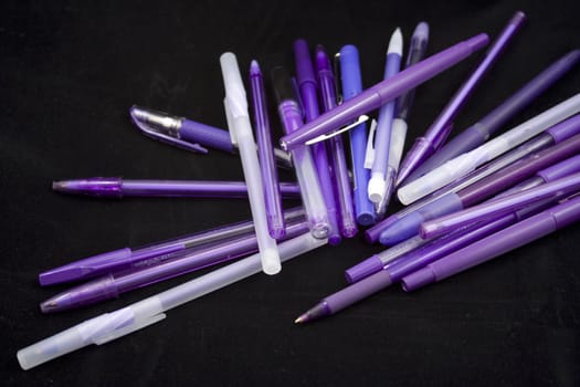 Pile of purple pens just waiting for someone to pick one up and start writing