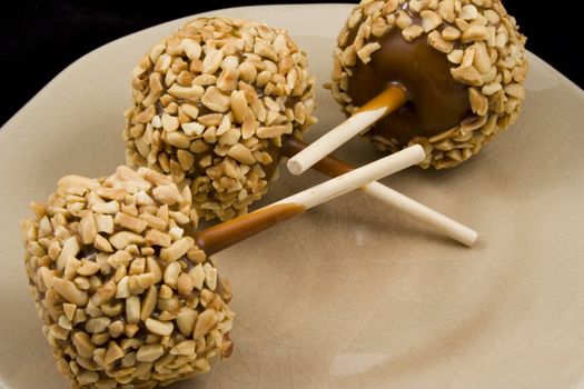 Carmel apples with nuts on a plate just in time for the holidays