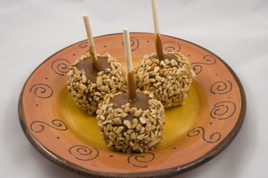 Carmel apples with nuts on a plate just in time for the holidays