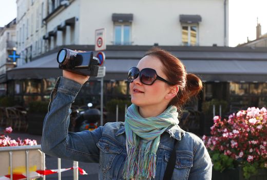 Girl using camcorder in the street Paris
