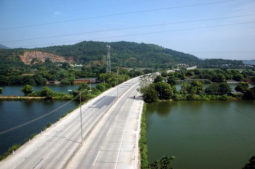 Chinese countryside, around town QingYuan in Guangdong province. General view with main road and lakes, hills.