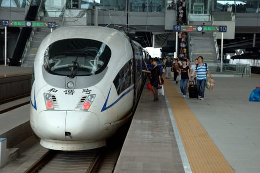 GUANGZHOU, CHINA - SEPTEMBER 29: China invests in fast and modern railway, trains with speed over 340 km/h. Passengers board train on September 29, 2010 in newly build Guangzhou South station.