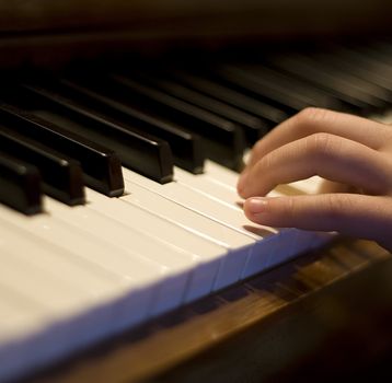 close-up of a piano hand and fingers on the keys, shallow dof nice music background