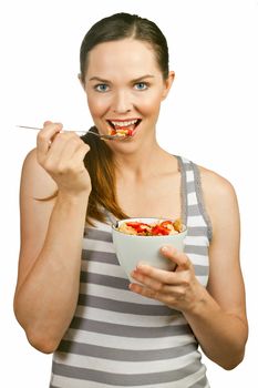 Portrait of a beautiful young woman eating a healthy bowl of cereal with strawberries. Isolated over white.