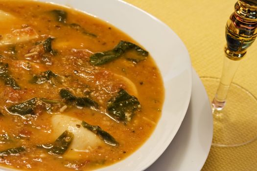 close up of a bowl of garlic spinach tortellini soup