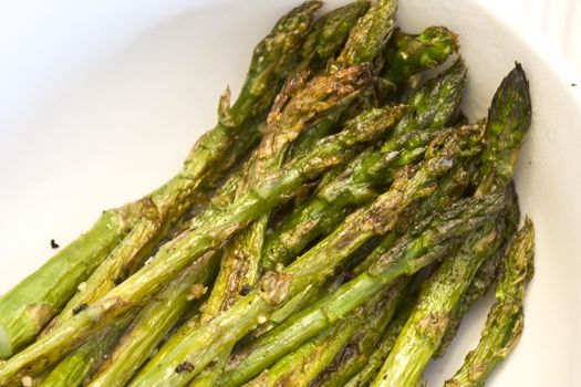 close up of cooked asparagus on a white plate