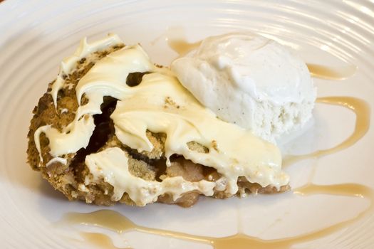 slice of apple pie frosted with vanilla ice cream on white plate