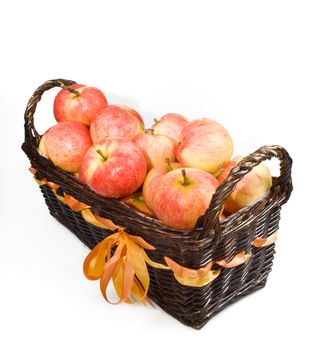 The wood basket with red apples on the white background