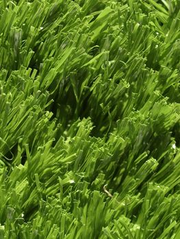 Detail of green grass artificial lawn meadow, useful as a background