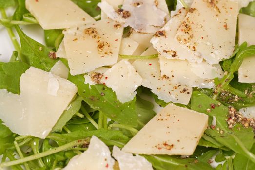 Rocket salad  garnished with parmesan cheese slices