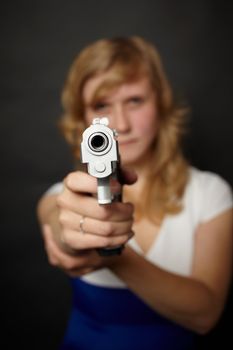 A woman aiming a gun on a black background