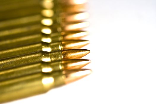 Row of rifle rounds on white sharp focus going to a nice blur