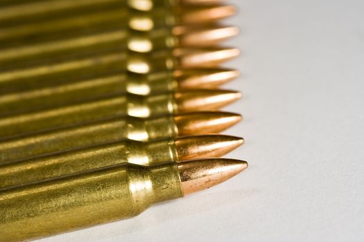 Row of rifle rounds on white sharp focus going to a nice blur