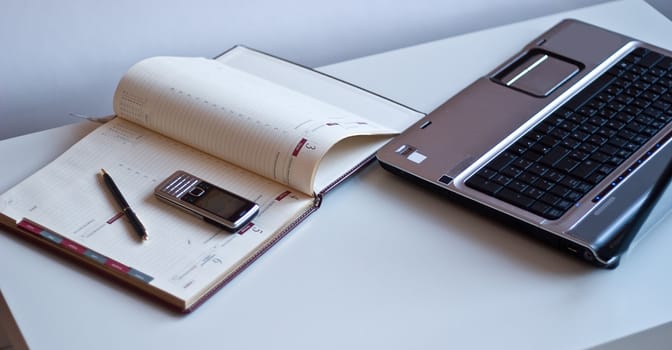 Business still-life. In the office: a laptop, notebook, mobile phone.