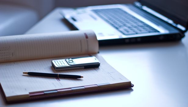 Business still-life. In the office: a laptop, notebook, mobile phone.