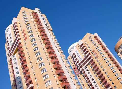 Modern tall residential building on a background of blue sky.