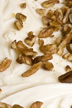 detail of the nuts on top of a slice of pumpkin cake with cream cheese frosting