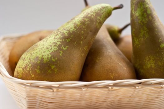 Pears in the basket on a gray background.
