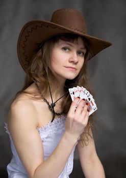 Portrait girl with a playing-cards in hand on black