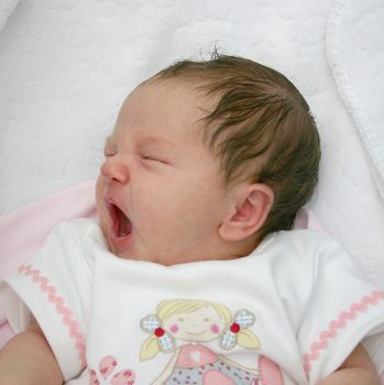 small newborn baby having a good yawn