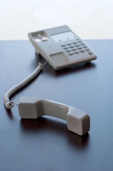 The white phone on the table. The concept of communication between people.