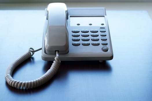 The white phone on the table. The concept of communication between people.
