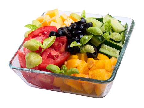 Sliced vegetables (tomatoes, peppers, olives and basil) and cheese in a transparent plate