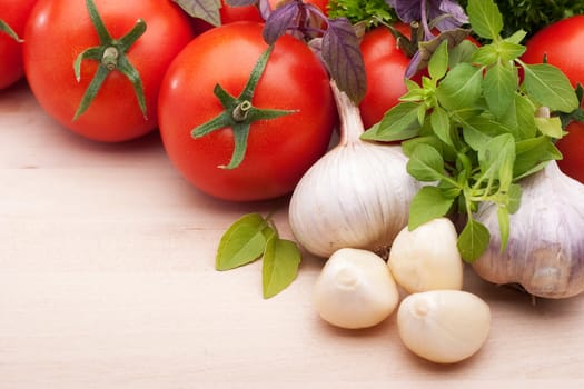 Still life: tomatoes, garlic and basil on a light background