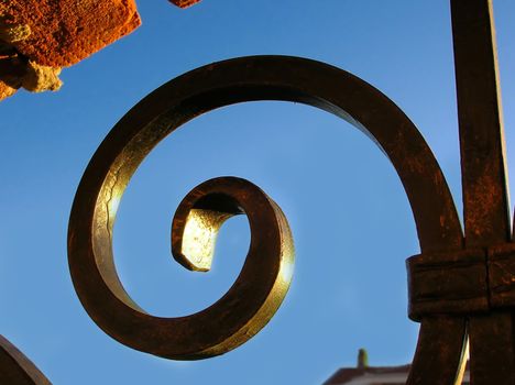 fragment of brick fence with forge iron details over blue