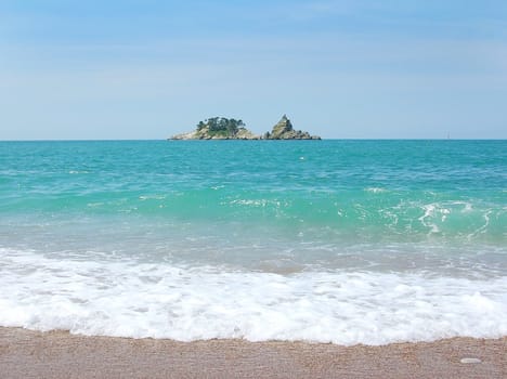 Small Island on horizon over water in adriatic sea in Montenegro
