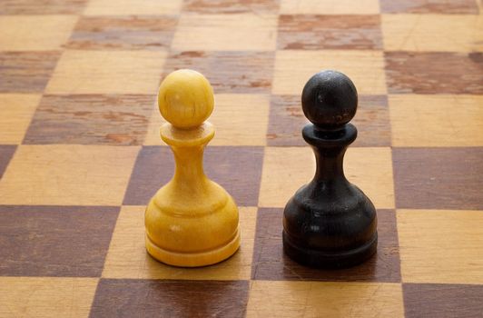 Pawns on a chessboard. The concept of battle, playing by the rules