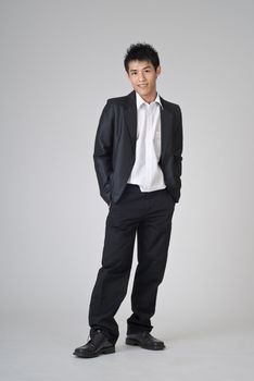 Young business man of Asian standing on studio gray background.