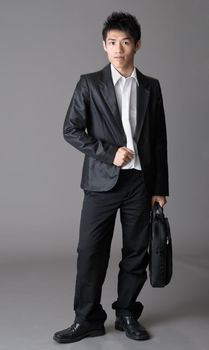 Immature business man of Asian over studio gray background.