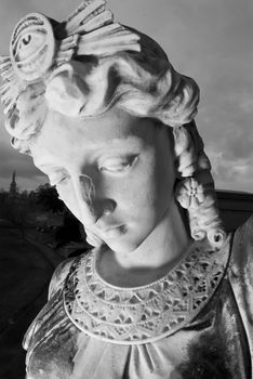 Close up of a mourning statue standing guard outside an egyptian style tomb.