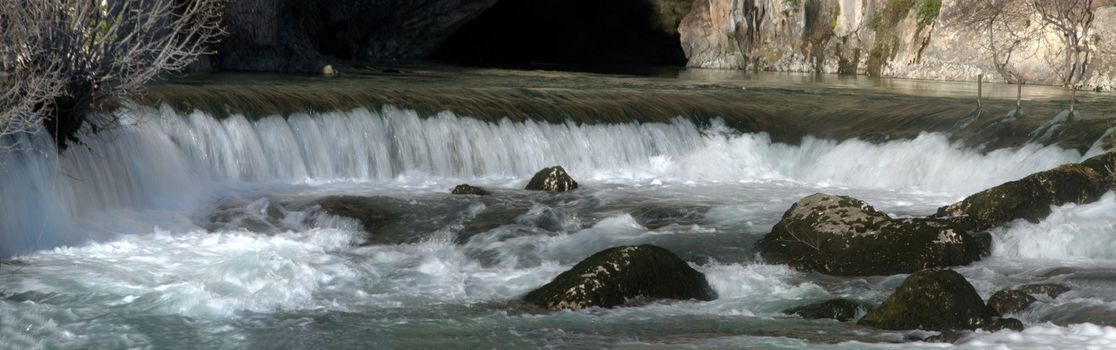 Source of the Buna river near Mostar in Bosnia and Herzegovina with water coming out of a cave on a sunny day.