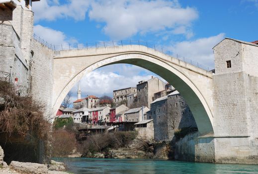 Old Bridge in Mostar, Bosnia and Herzegovina with the old town and blue sky in background