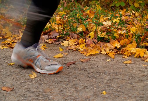 A woman jogging on a cloudy autumn day
