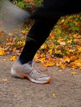 A woman jogging on a cloudy autumn day
