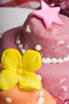 two small nicely decorated cakes yellow and pink 