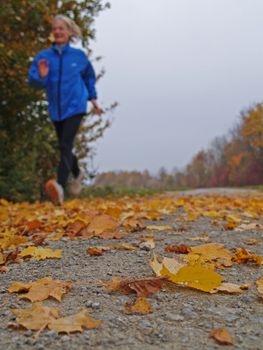 A woman jogging on a cloudy autumn day
