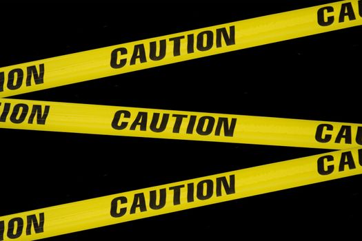 criss crossing caution tape on a black background